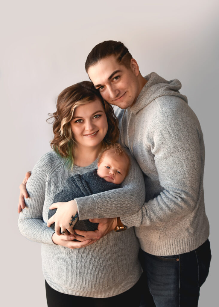 studio newborn session, family of 3 smiling at camera