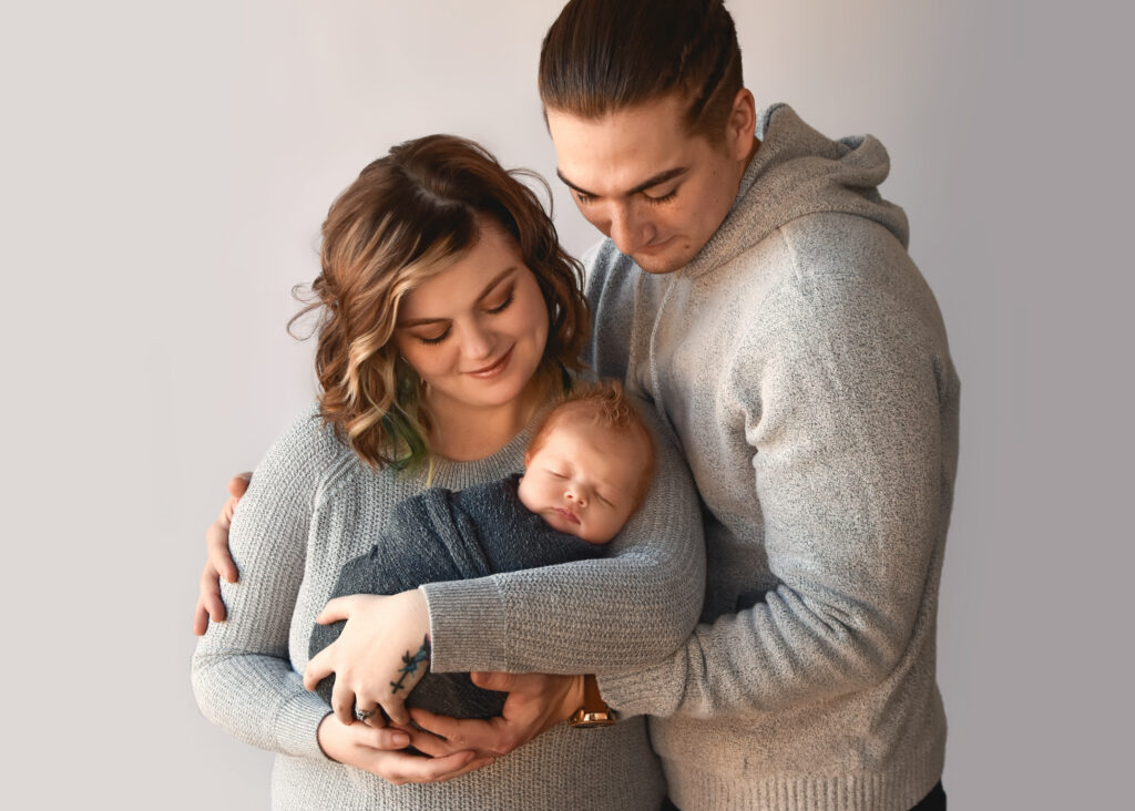 studio newborn session, mom and dad looking at baby