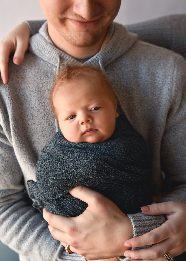 studio newborn session, dad holding baby close