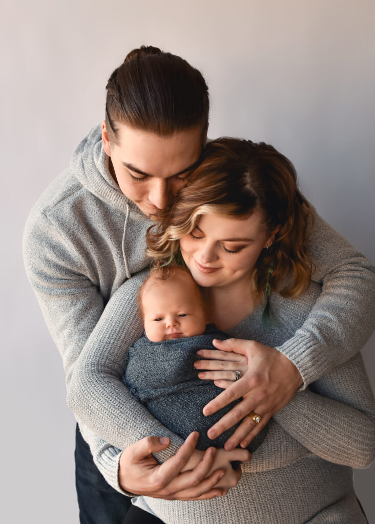 studio newborn session, dad holding mom and baby