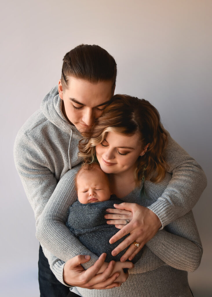 studio newborn session, dad loving on mom and baby