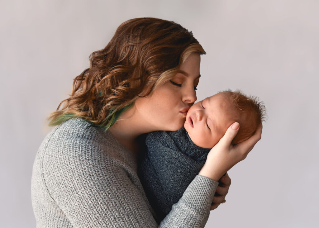 studio newborn session, mom kissing baby on cheek