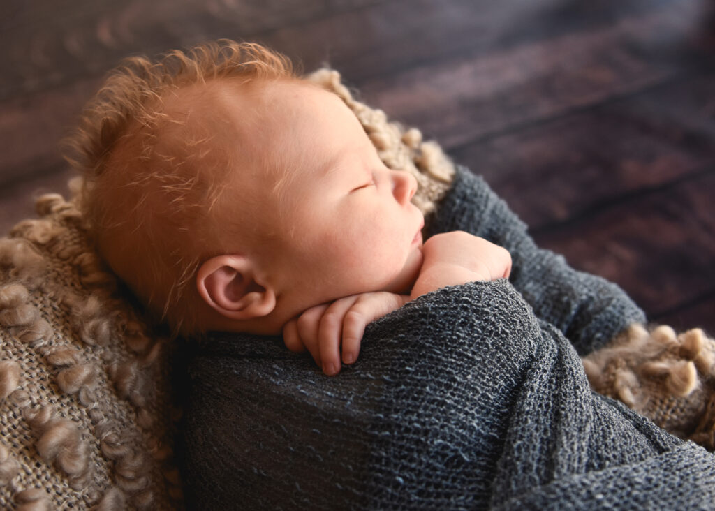 studio newborn session, baby with fluffy curls in hair