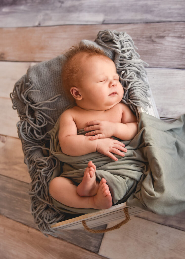 studio newborn session, baby with neutral grey setup, hands and feet out