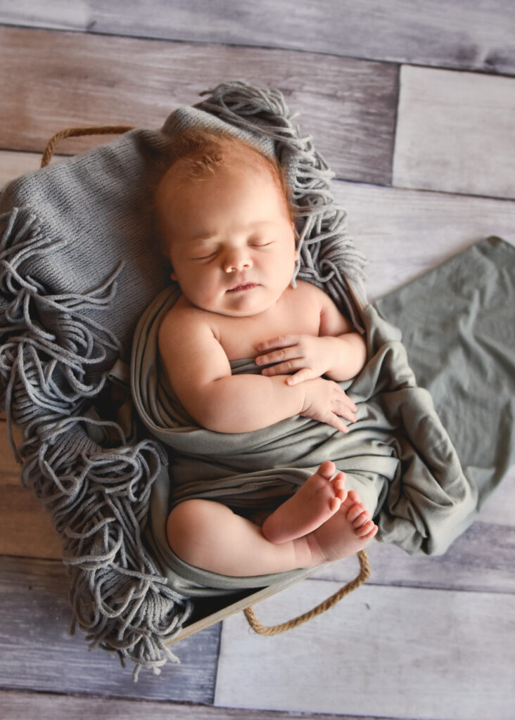 baby wrapped in grey on grey background